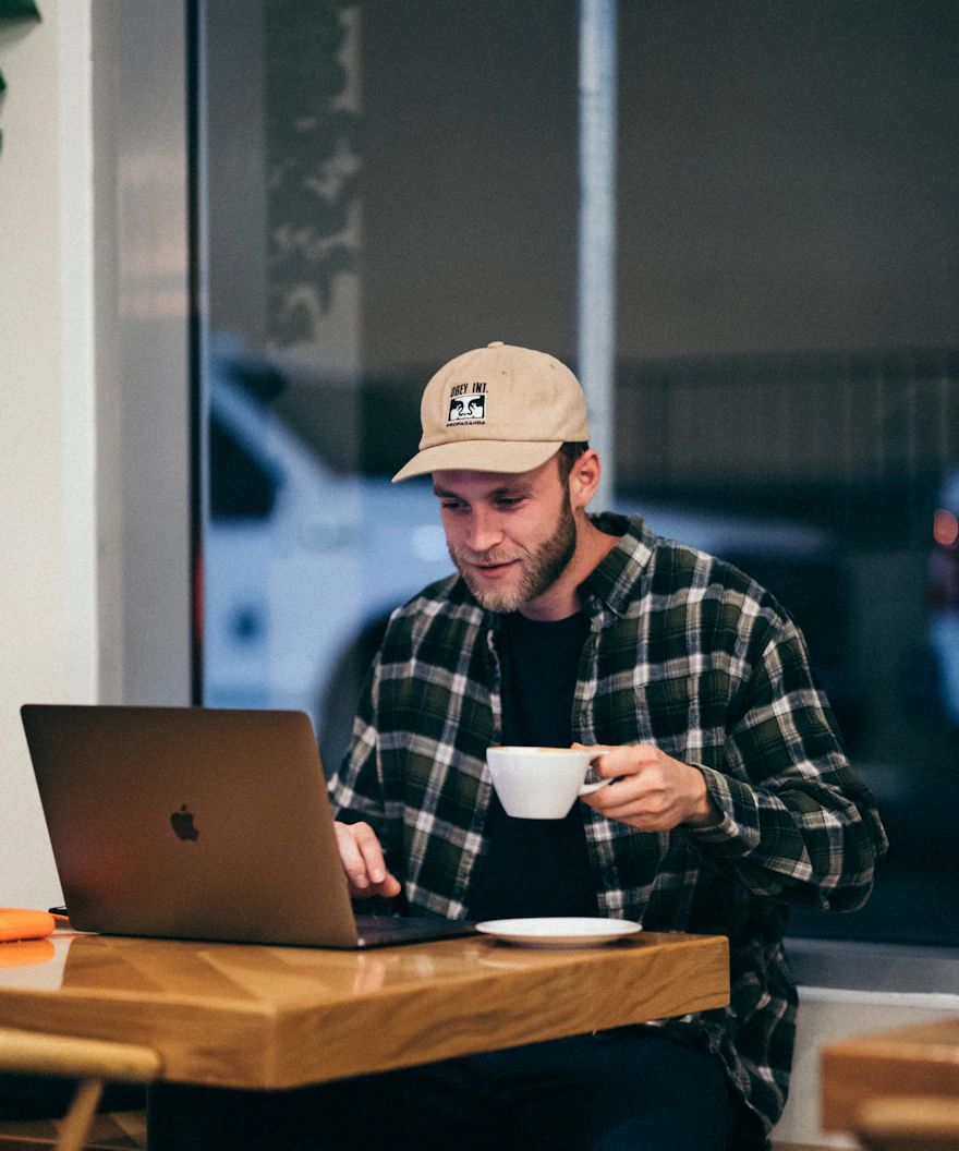 Desenvolvedor tomando café enquanto acessa o servidor no notebook